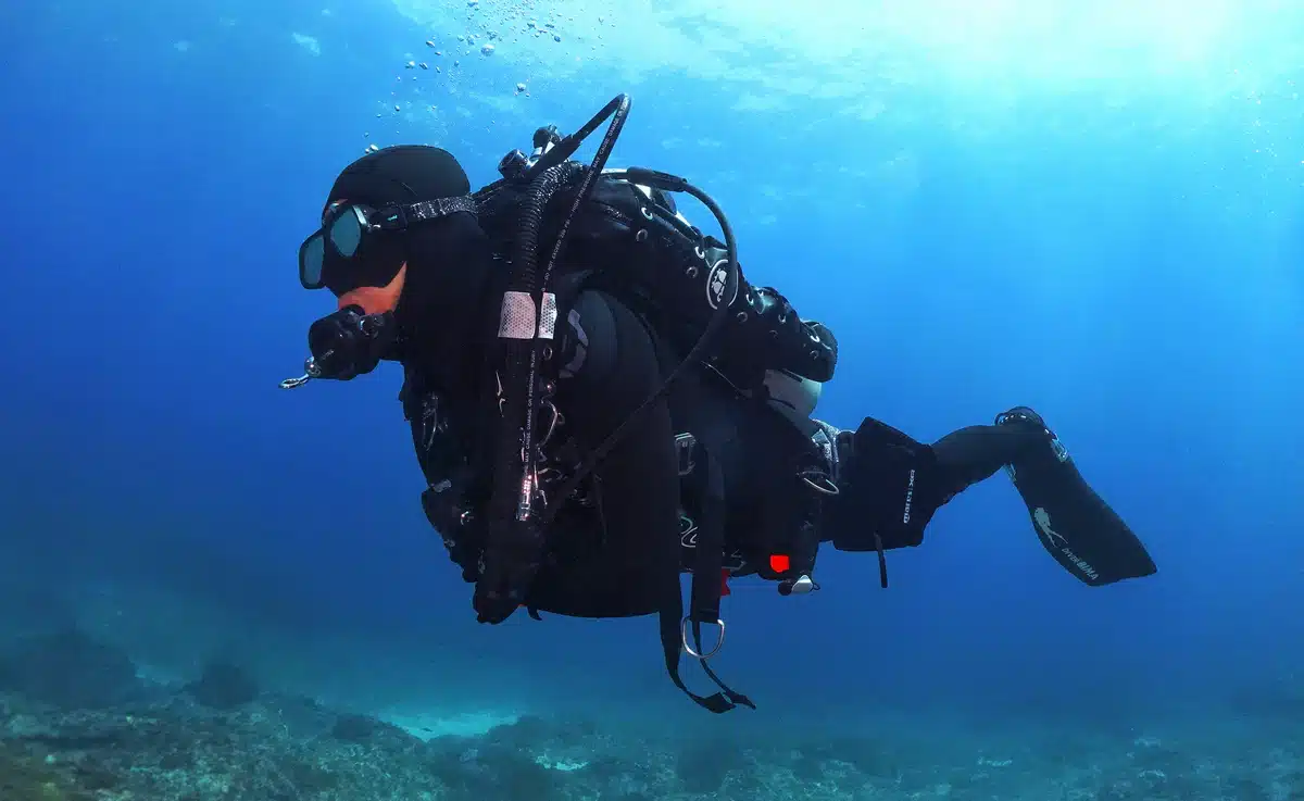 scuba diver floating horizontally and relaxed in mid-water